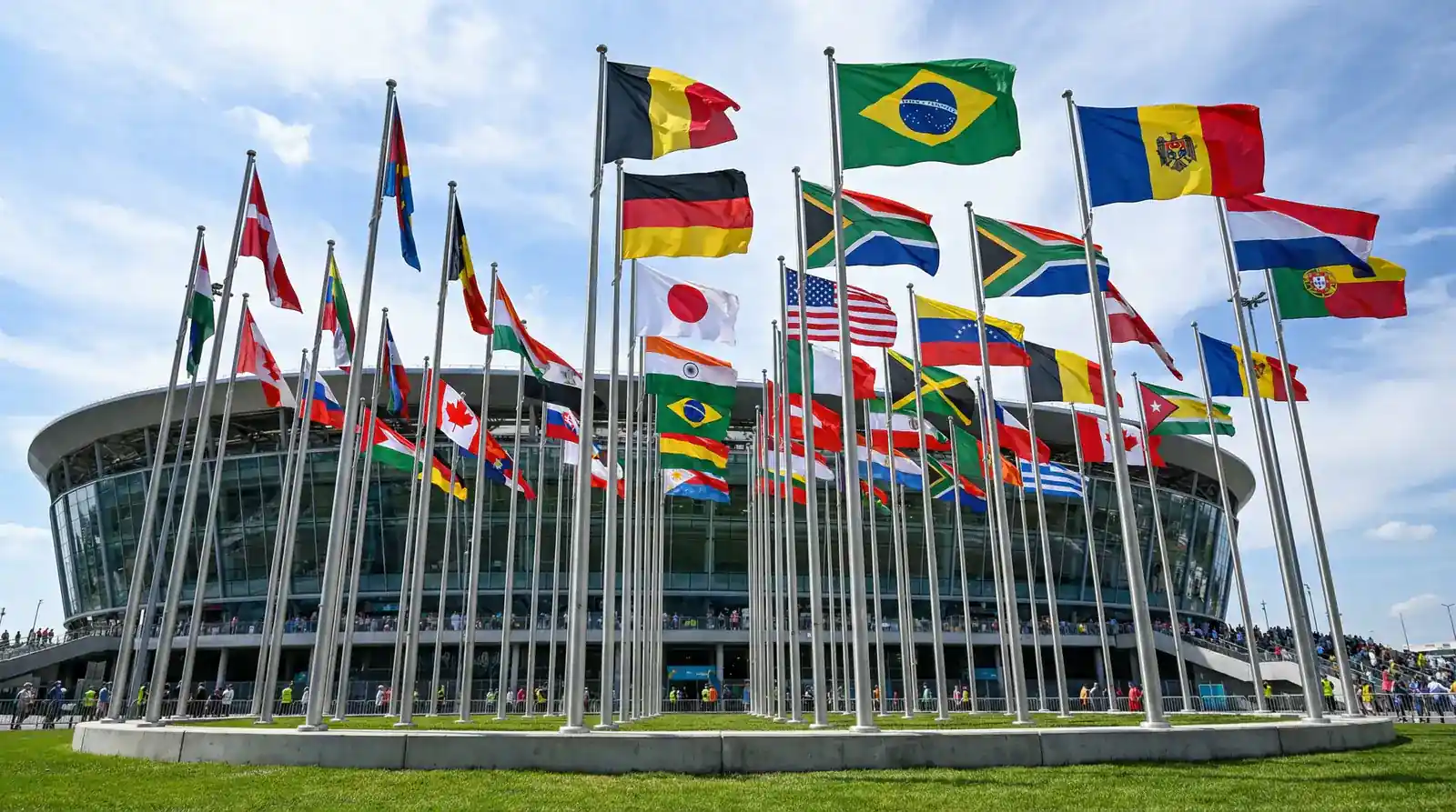 Drapeaux des équipes qualifiées pour les groupes de la Coupe du Monde 2026 disposés autour d'un terrain
